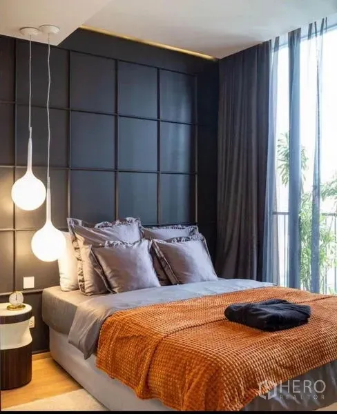 公寓 出租在Watthana, Bangkok - 第二卧室，橙色毯子搭配现代吊灯，落地窗外可见绿意。