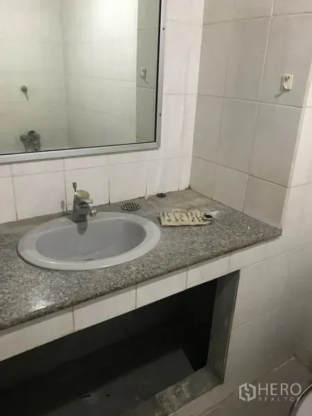Office Space for rent in Khlong Toei, Bangkok - Compact bathroom with granite countertop sink, wall mirror and white tiles.