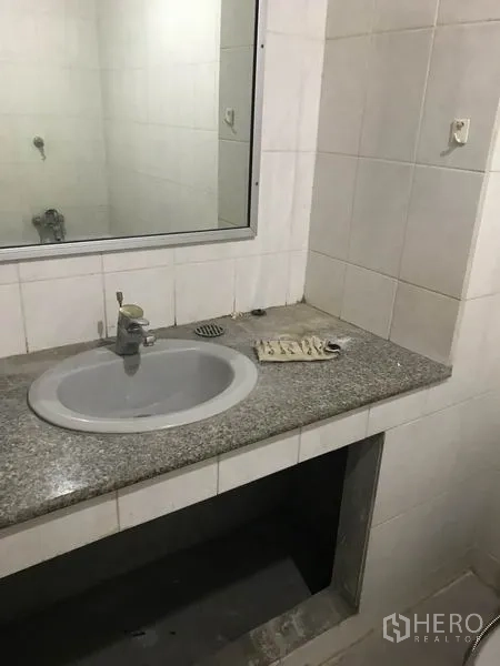 Office Space for rent in Khlong Toei, Bangkok - Compact bathroom with granite countertop sink, wall mirror and white tiles.