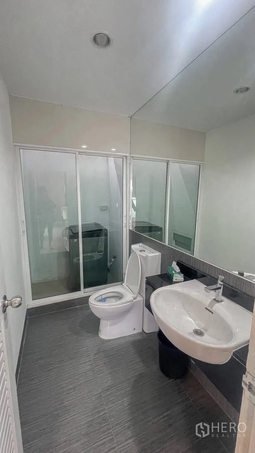 บ้านเดี่ยว for rent or sale in Saphan Sung, Bangkok - ห้องน้ำมีฉากกระจกกั้นอาบน้ำและโซนวางเครื่องซักผ้า.