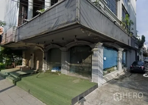 店屋 出租在Watthana, Bangkok - 转角店屋外立面，拱形橱窗与卷帘门，临人行道。