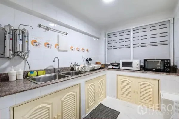 联排别墅 出租在Bang Rak, Bangkok - 白色瓷砖厨房，双水槽、石材台面和小家电。