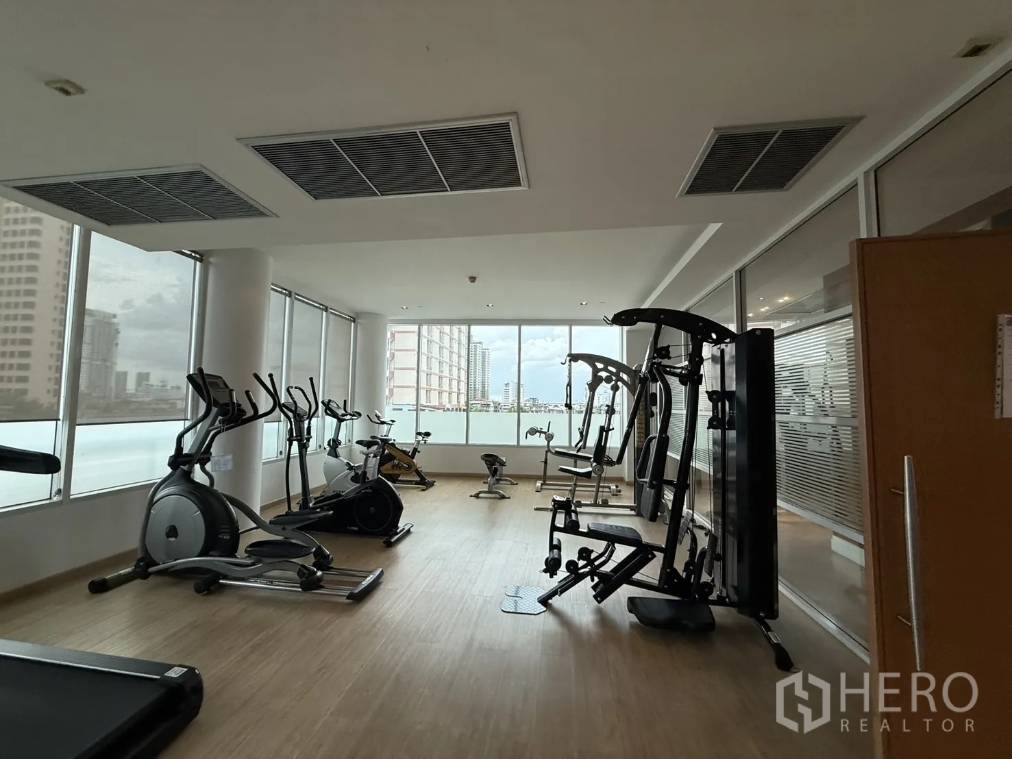 Condominium for rent in Phaya Thai, Bangkok - Fitness center with cardio and weight machines and wide window views.