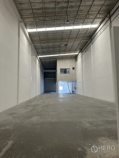 Factory for rent in Khlong Luang, Pathum Thani - High-bay warehouse interior showing about 9.3 m clear height, concrete floor, and mezzanine office.