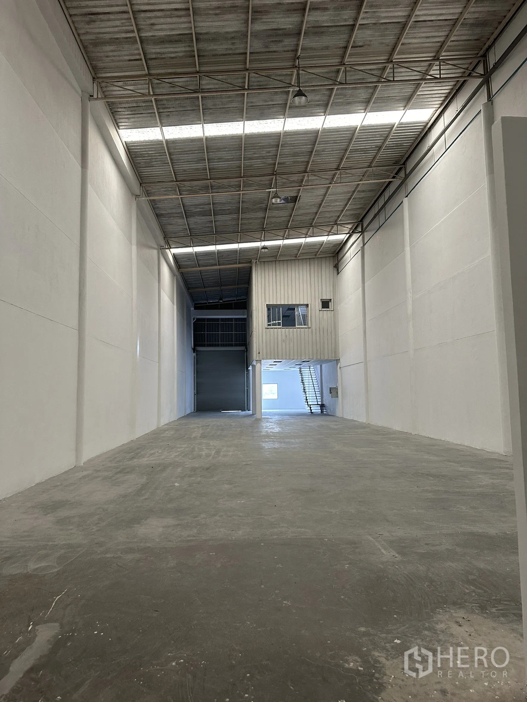 Factory for rent in Khlong Luang, Pathum Thani - High-bay warehouse interior showing about 9.3 m clear height, concrete floor, and mezzanine office.