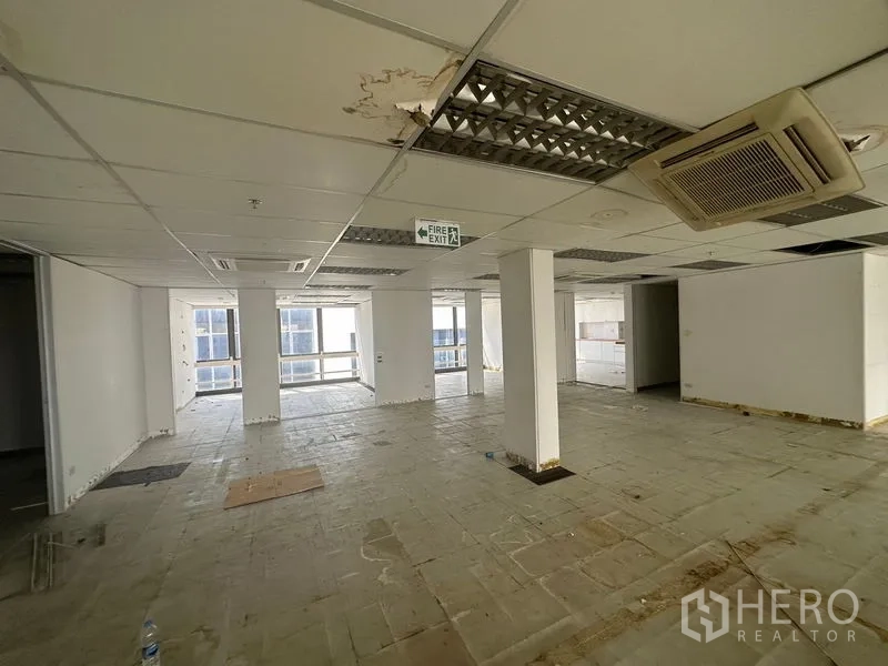 办公空间 出租在Khlong Toei, Bangkok - 部分装修的办公区，设立柱、嵌入式空调与消防出口指示，临大窗。
