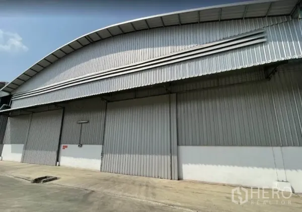 Warehouse for rent in Bang Pa-in, Phra Nakhon Si Ayutthaya - Metal-clad warehouse exterior with large sliding doors and arched roof in Bang Pa-in, Phra Nakhon Si Ayutthaya.