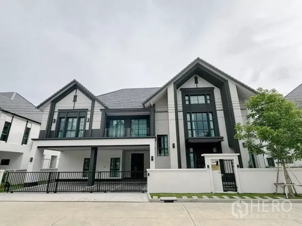 บ้าน ให้เช่าหรือขายในBang Phli, Samut Prakan - บ้านเดี่ยวสองชั้นสไตล์โมเดิร์น หลังคาทรงจั่ว หน้าต่างบานใหญ่ พร้อมรั้วและที่จอดรถ
