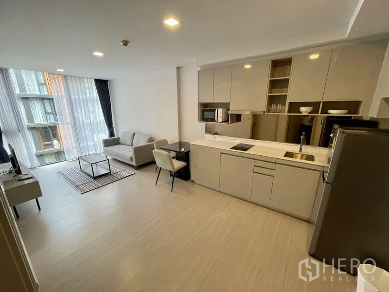 公寓 出租在Khlong Toei, Bangkok - 开放式起居空间连现代一字型厨房与用餐区，配大窗户。