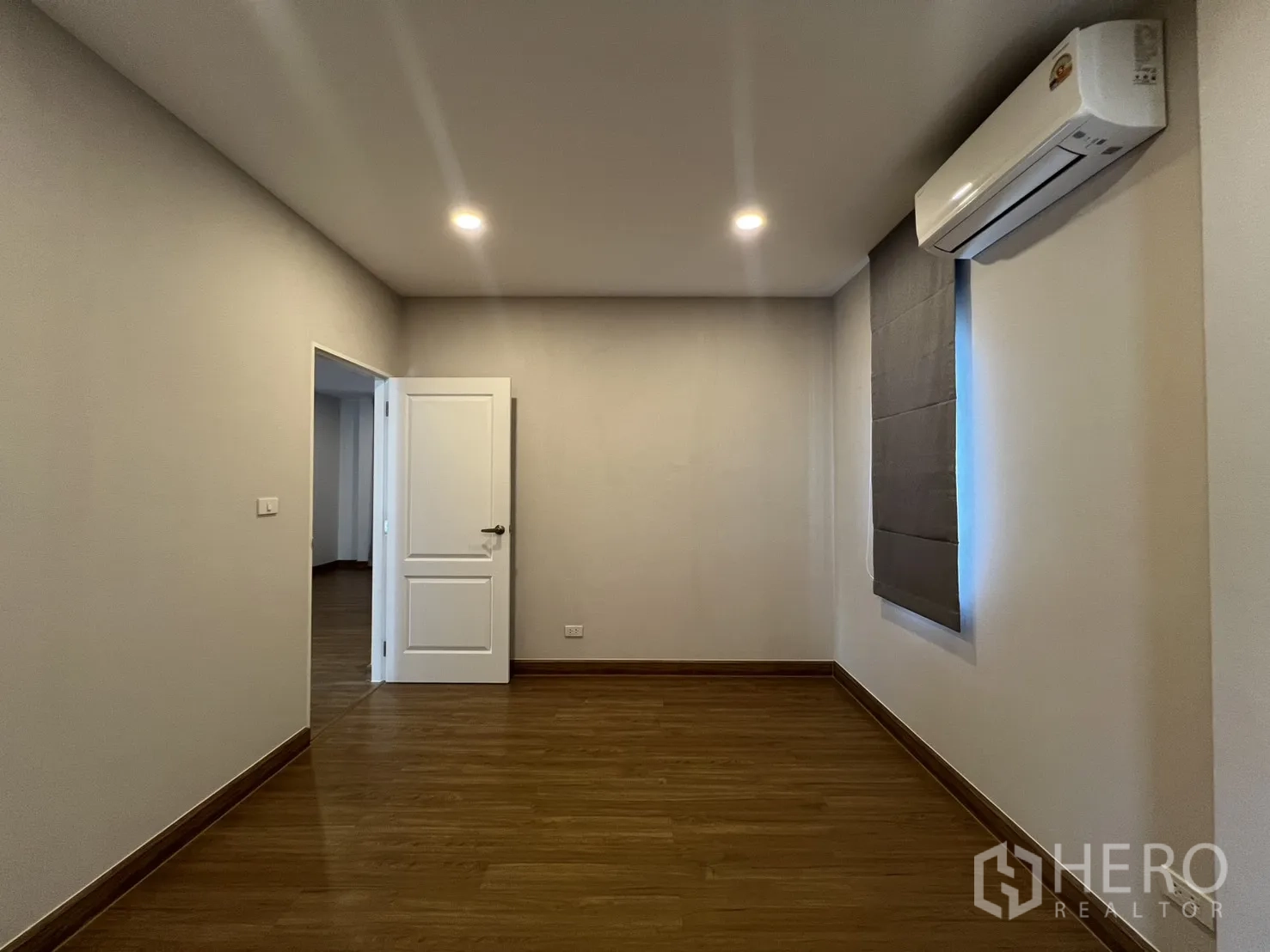 独栋房屋 for rent in Lat Krabang, Bangkok - 简约卧室配空调、木地板、嵌灯与窗帘。