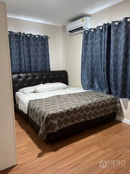 Detached House for rent in Bang Kapi, Bangkok - Cozy second bedroom with double bed, dark curtains, wood flooring, and air-conditioning.