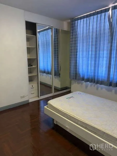 独立式住宅 出租在Bang Kapi, Bangkok - 卧室配单人床、镜面衣柜和侧边搁架。