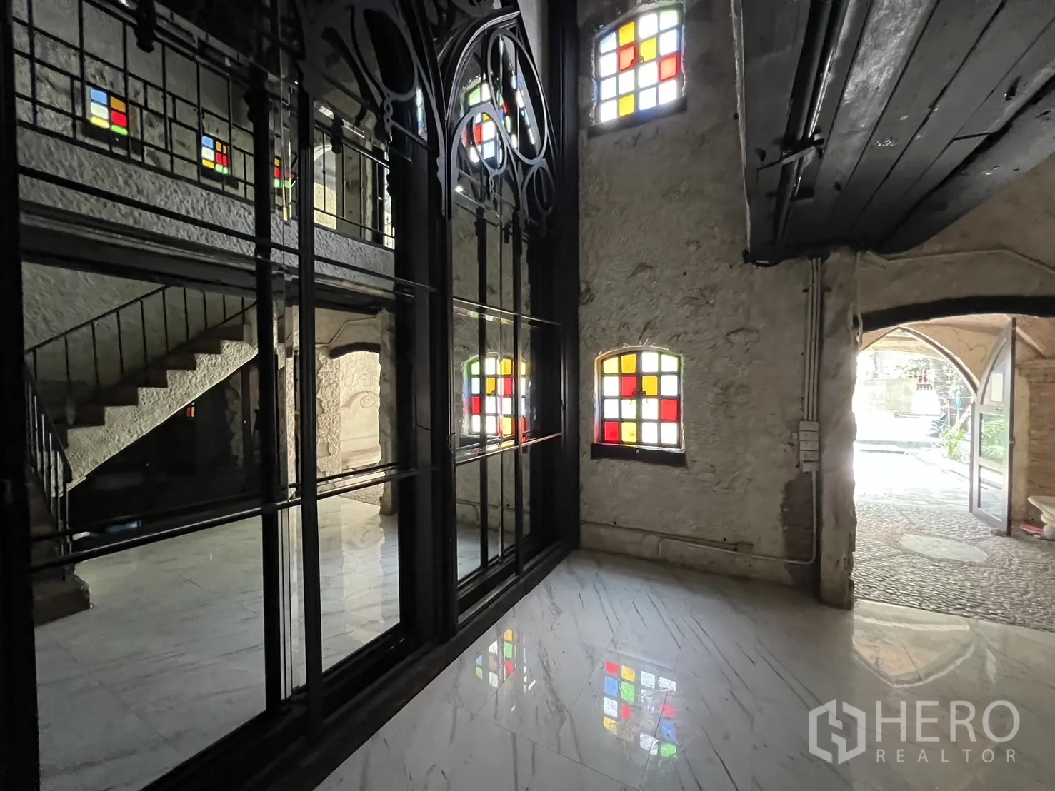 Retail Space for rent in Watthana, Bangkok - Ground-floor lobby with black metal framed glass wall, staircase and marble flooring.