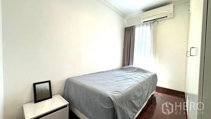 Condominium for rent or sale in Watthana, Bangkok - Compact secondary bedroom with window, air-conditioning, and wardrobe.