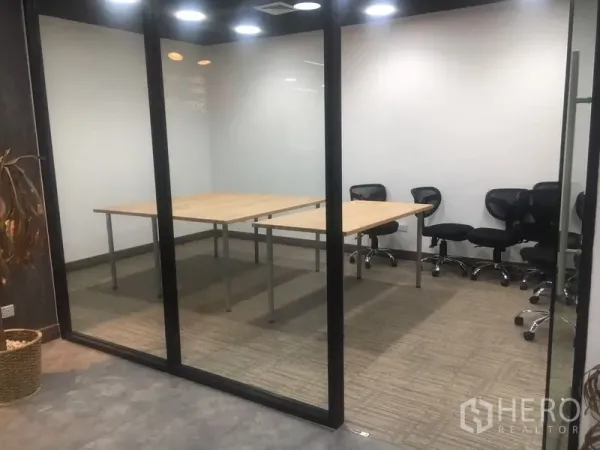 Office Space for rent in Sathon, Bangkok - Glass-walled meeting room with rectangular tables and swivel chairs on carpet flooring.
