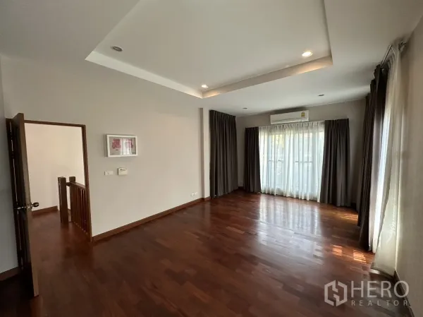 独立式住宅 出租或出售在Pak Kret, Nonthaburi - 主卧铺木地板，吊顶与大面积采光窗。