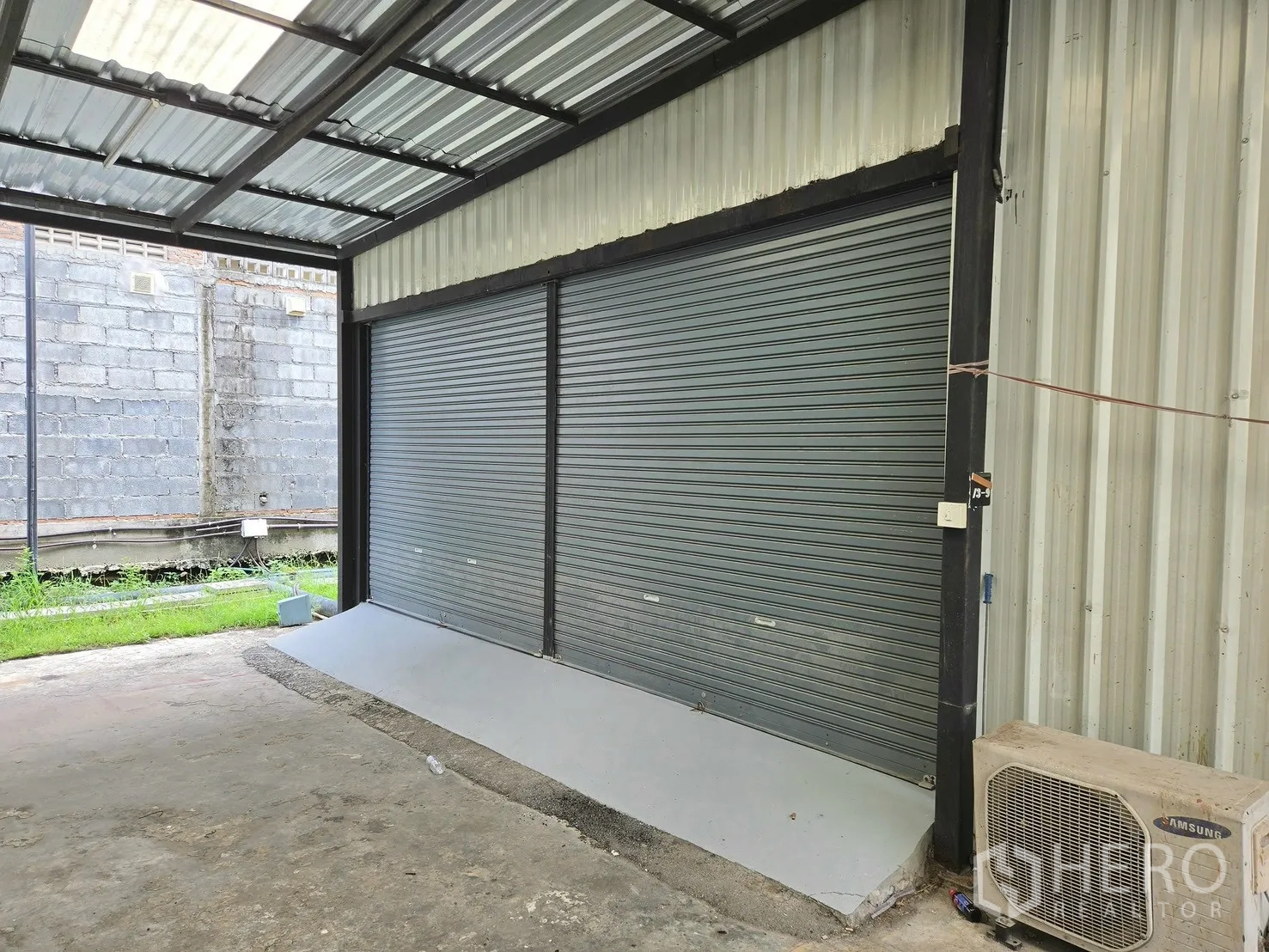 โกดัง for rent in Suan Luang, Bangkok - พื้นที่โหลดสินค้ามีหลังคาพร้อมประตูม้วนคู่และทางลาดขนถ่ายสินค้า.