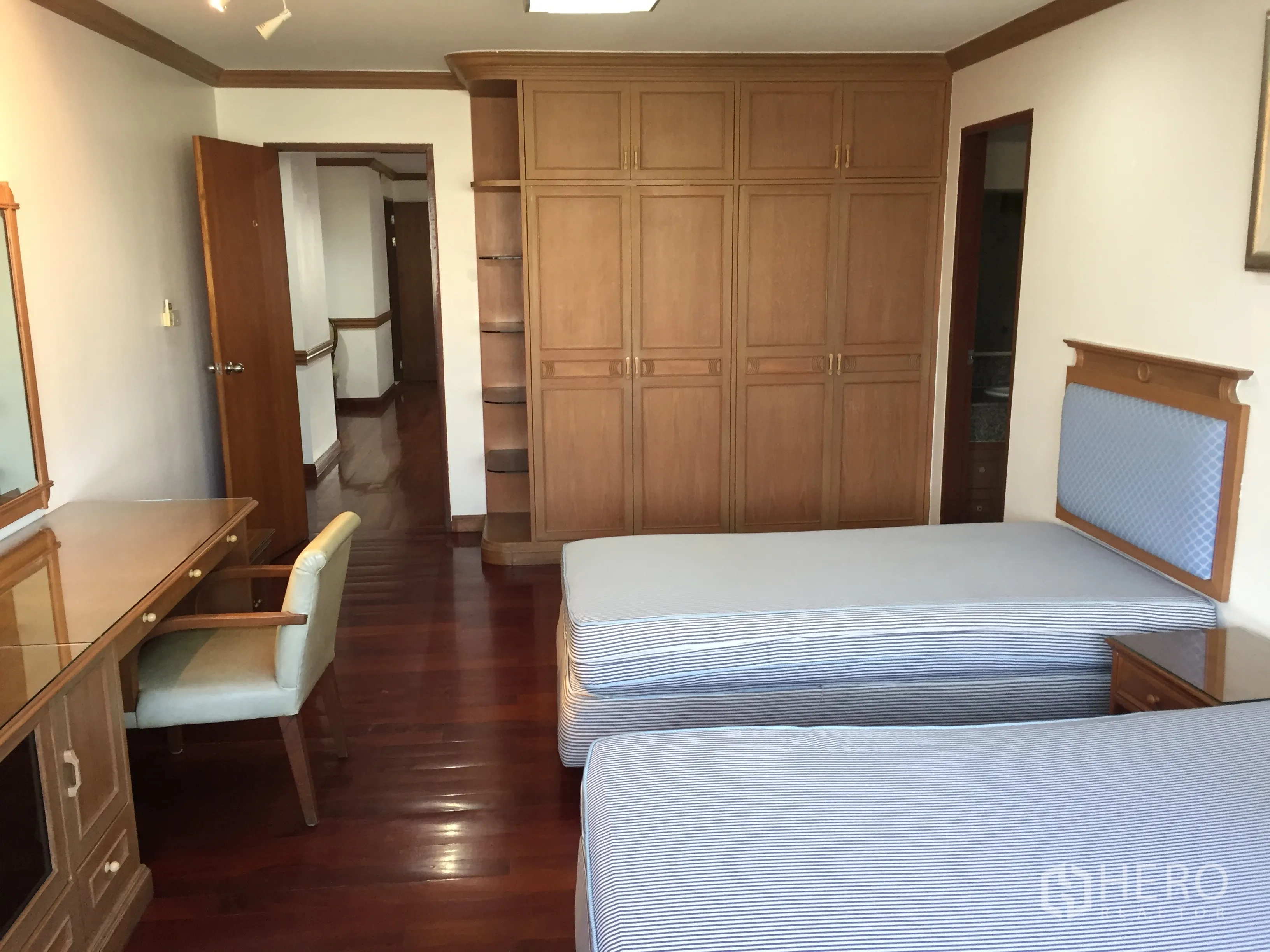公寓 出租在Watthana, Bangkok - 明亮的双床卧室，配书桌、大量衣柜与亮泽木地板。
