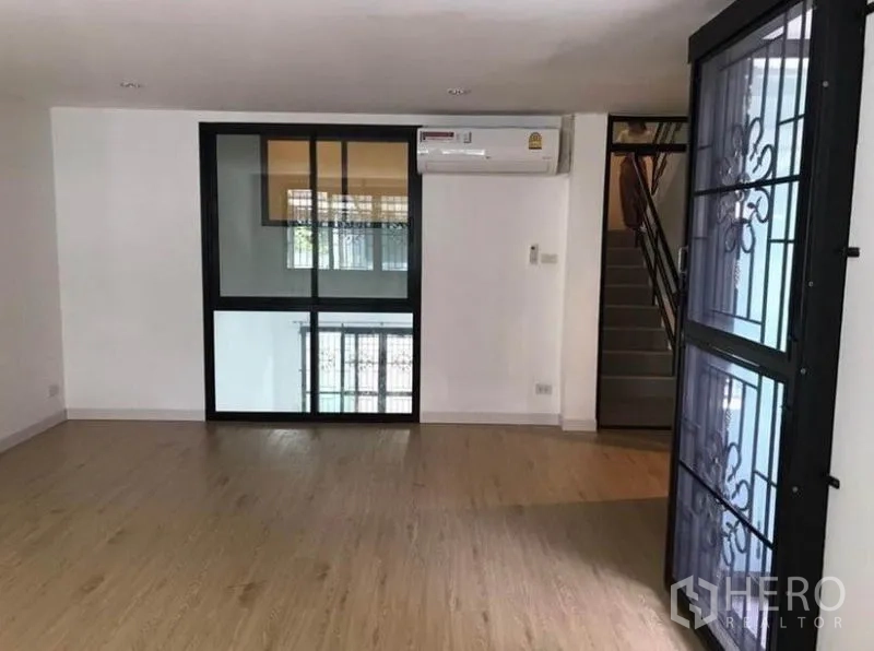 联排别墅 出租在Wang Thonglang, Bangkok - 二层家庭区，玻璃隔断、空调及楼梯入口。