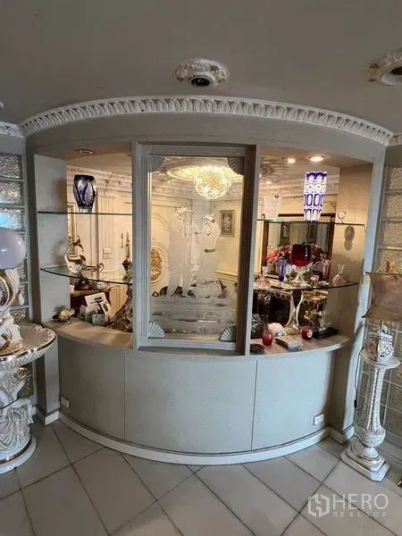 Condominium for sale in Khlong Toei, Bangkok - Curved display niche with etched glass window and glass shelving showcasing collectibles under warm lighting.