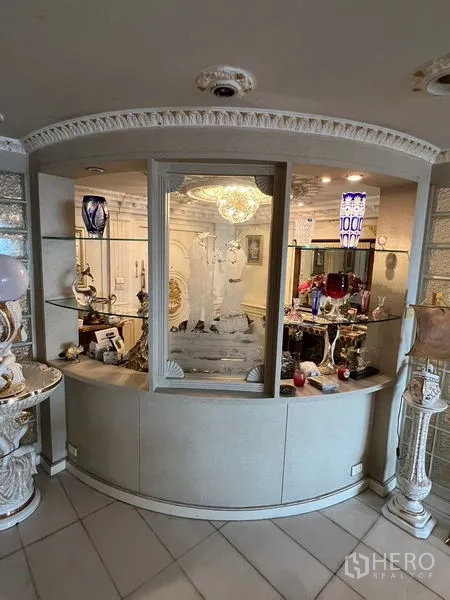 Condominium for sale in Khlong Toei, Bangkok - Curved display niche with etched glass window and glass shelving showcasing collectibles under warm lighting.