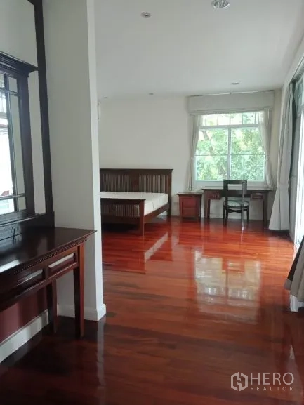 Detached House for rent in Bang Rak, Bangkok - Suite-style bedroom with dressing table, study nook and gleaming hardwood floors.
