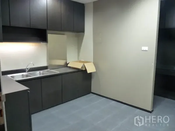 Office Space for rent in Watthana, Bangkok - Modern pantry featuring a double sink, dark cabinetry and grey floor tiles.