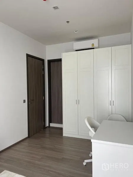 Condominium for rent in Bang Kho Laem, Bangkok - Guest bedroom with white wardrobe, study desk, and air conditioner.