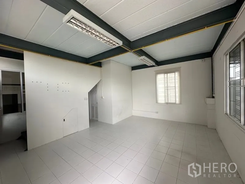 Factory for rent in Bang Bua Thong, Nonthaburi - Bright second-floor office with tiled flooring, fluorescent lighting and window, connected by internal stairs.