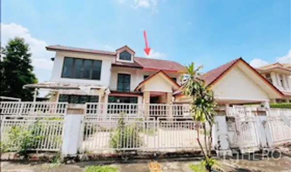 Detached House for sale in Khan Na Yao, Bangkok - Front view of a two-storey detached house with red gable roof and a white gated fence and driveway.