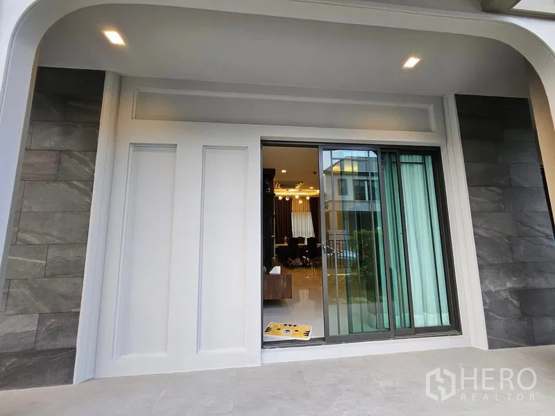 独立式住宅 出售在Mueang Pathum Thani, Pathum Thani - 带顶棚的露台，推拉落地门连接室内。