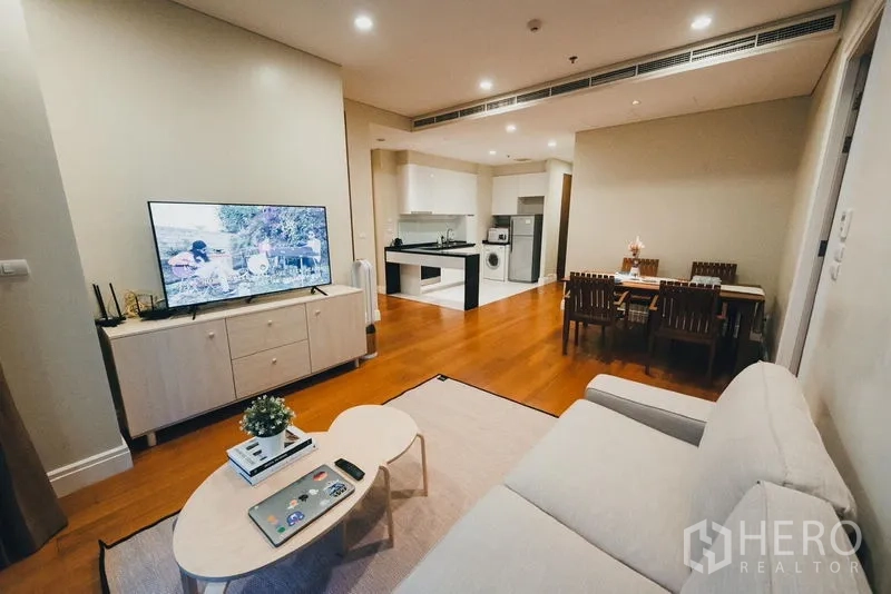 Condominium for rent in Khlong Toei, Bangkok - Open-plan living, dining and kitchen layout with sofa, TV and dining set.
