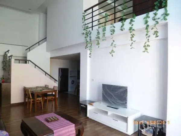 公寓 出租在Pathum Wan, Bangkok - 明亮的挑高客餐厅，带电视柜、通往夹层的楼梯与垂挂绿植。