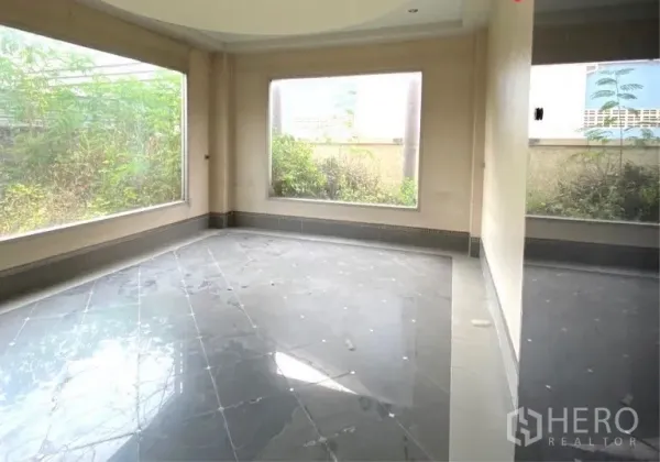 Warehouse for rent or sale in Mueang Samut Sakhon, Samut Sakhon - Ground-floor room with large picture windows, grey tile flooring, and views of the garden outside.