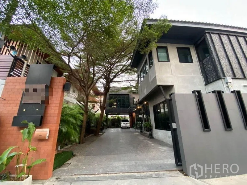 办公空间 出租在Bang Kapi, Bangkok - 大门与车道，现代两层办公楼，绿树成荫。