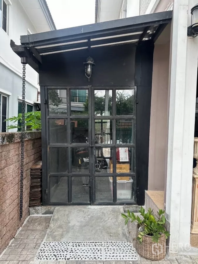บ้าน ให้เช่าในSuan Luang, Bangkok - ทางเข้าห้องเก็บของด้านข้าง ประตูกระจกกรอบเหล็กสีดำ พร้อมทางลาด.