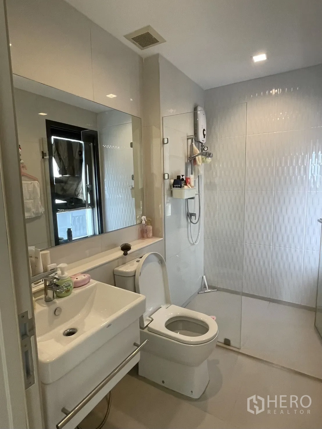 公寓 for rent in Pathum Wan, Bangkok - 现代化浴室，设有大镜面、白色洗手台、坐便器和玻璃步入式淋浴间。