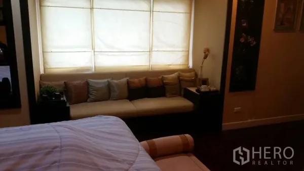 Detached House for rent in Lat Krabang, Bangkok - Cozy bedroom lounge corner with a long sofa under soft window blinds.