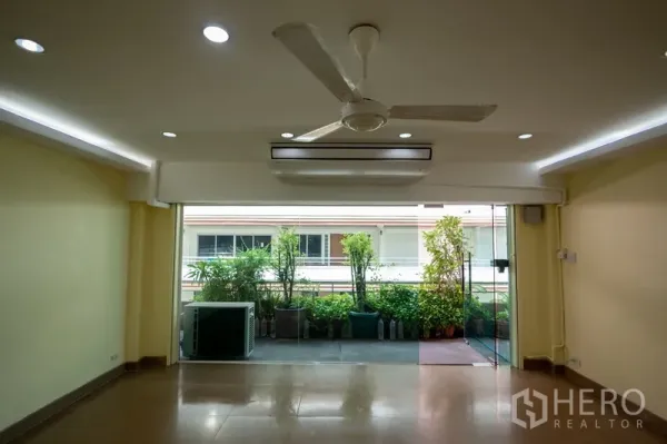 สำนักงานที่บ้าน ให้เช่า - มุมใกล้ของประตูกระจกบานเลื่อน เปิดสู่ระเบียงสวนกระถาง พร้อมคอมเพรสเซอร์แอร์
