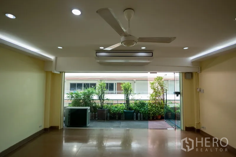 สำนักงานที่บ้าน ให้เช่า - มุมใกล้ของประตูกระจกบานเลื่อน เปิดสู่ระเบียงสวนกระถาง พร้อมคอมเพรสเซอร์แอร์