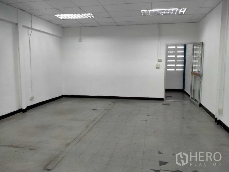 Warehouse for rent in Bang Phli, Samut Prakan - Empty office room with tiled floor and white walls inside the warehouse.