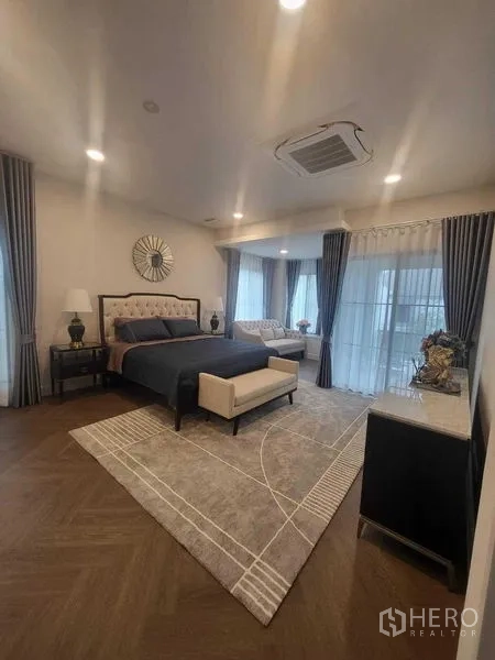 Detached House for rent in Saphan Sung, Bangkok - Spacious master bedroom with seating area and floor-to-ceiling windows.