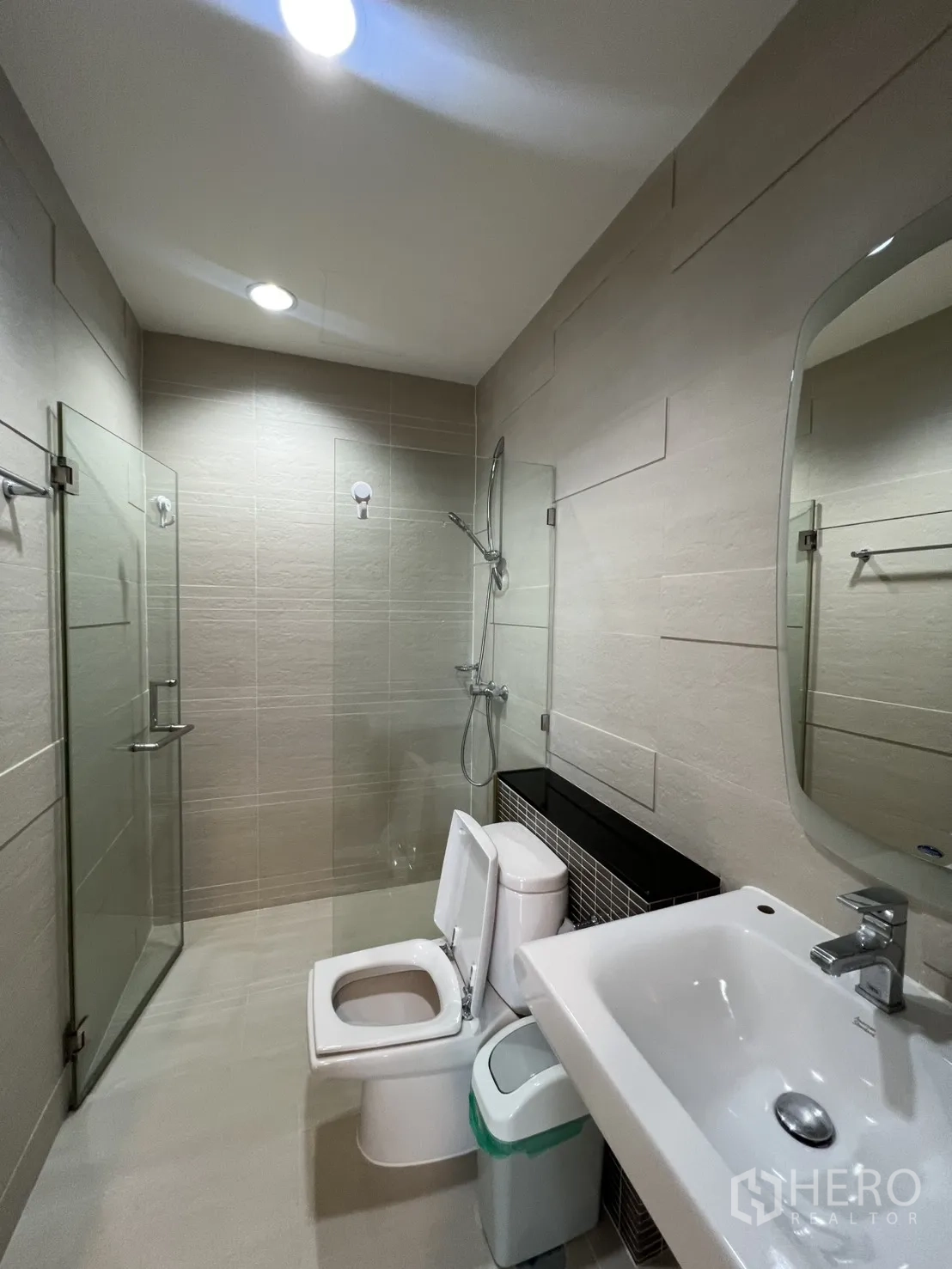 公寓 for rent in Bang Kapi, Bangkok - 现代浴室，设有玻璃淋浴间、坐便器与洗手台。