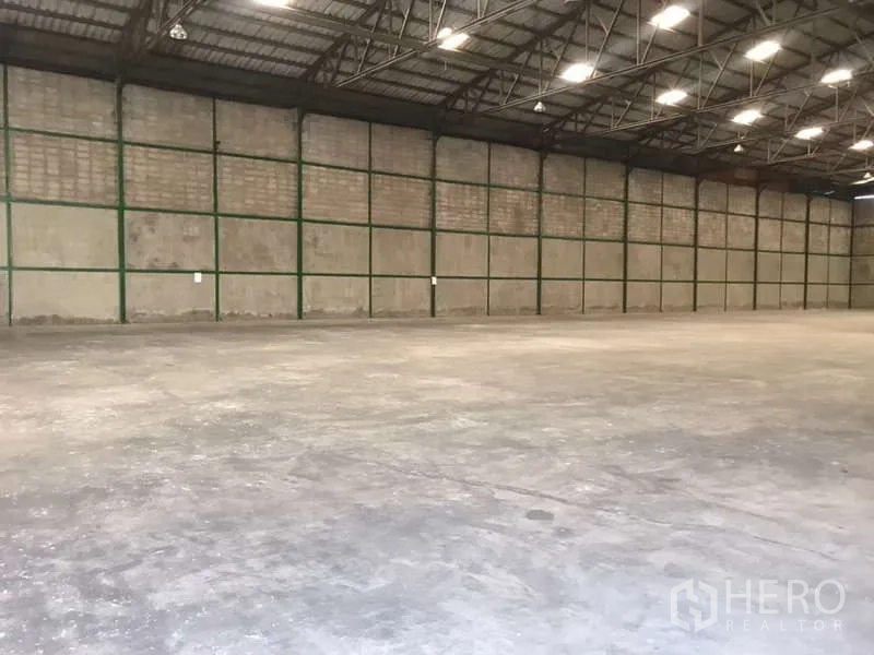 Factory for rent in Bang Pakong, Chachoengsao - Long-span factory bay with ribbed roof, reinforced walls and flat concrete slab.
