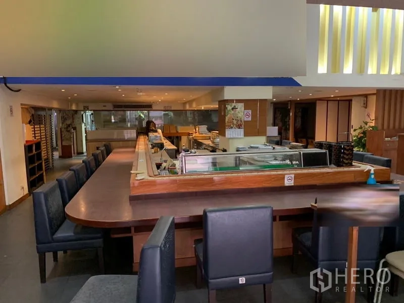 零售空间 出租在Bang Rak, Bangkok - 带长吧台和软包座椅的用餐区广角视图。