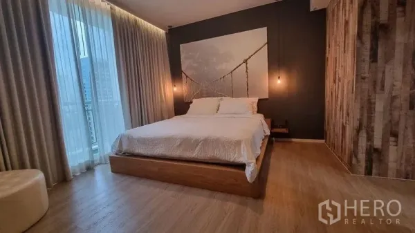 公寓 出租在Watthana, Bangkok - 主卧配平台床、吊灯、木地板与落地窗帘。