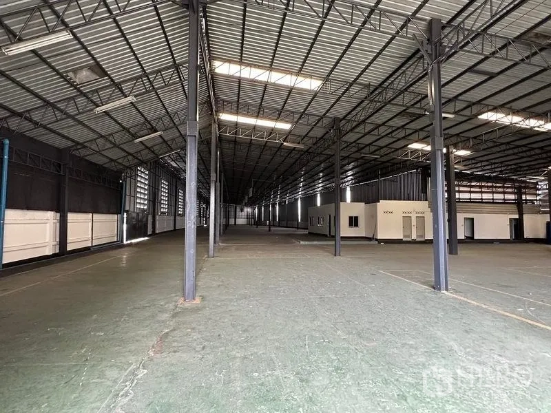 Warehouse for rent in Khan Na Yao, Bangkok - Wide warehouse bay with skylight roof panels and adjacent office rooms.