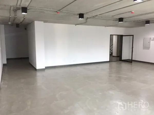 办公空间 出租在Khlong Toei, Bangkok - 87㎡开放式办公室，抛光水泥地、白墙、外露吊顶照明与玻璃入户门。