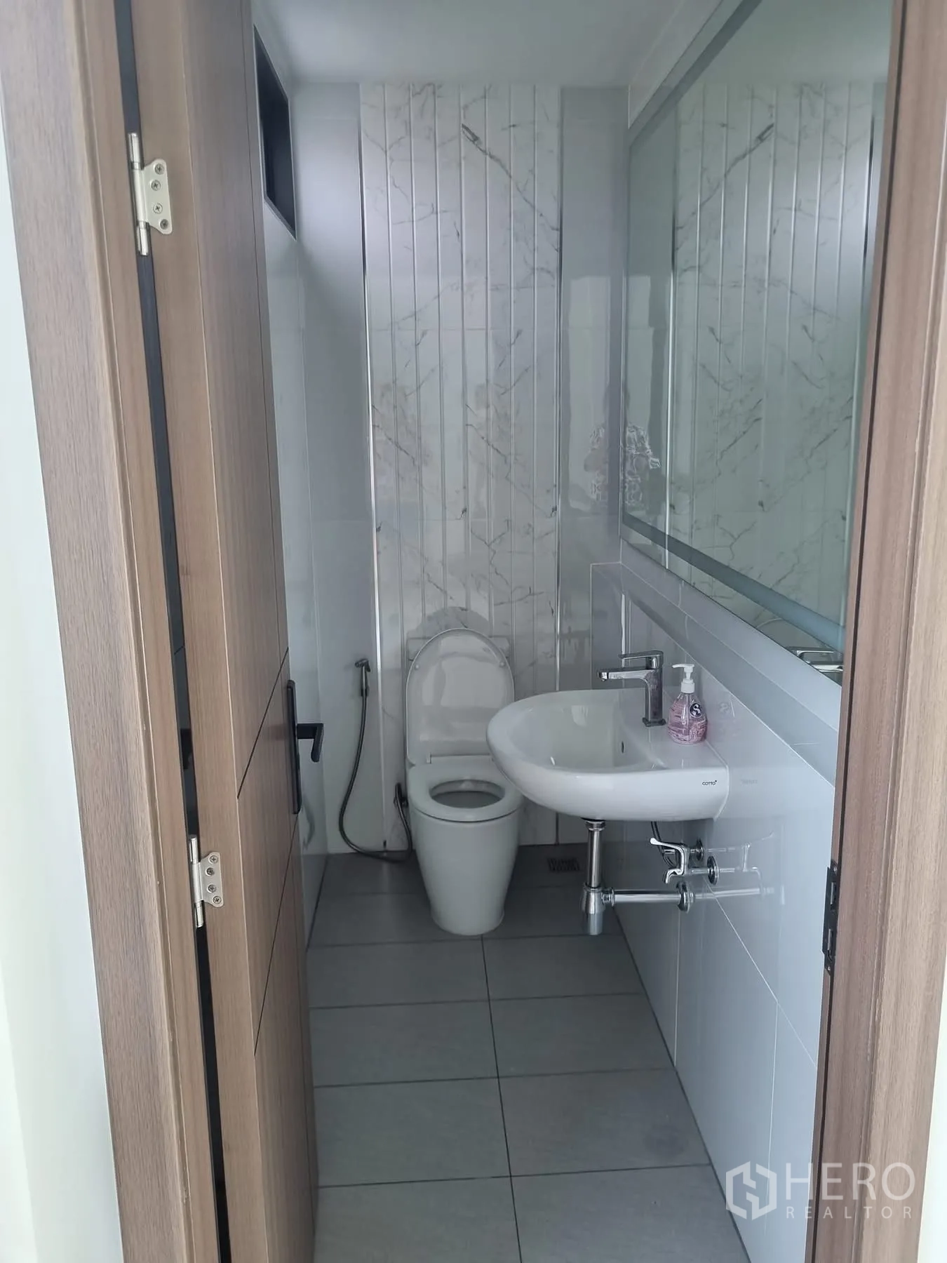 Home Office for rent in Khlong Toei, Bangkok - Guest bathroom with white fixtures and tiled walls.