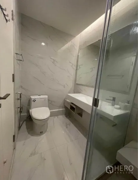 Detached House for rent in Lat Krabang, Bangkok - Modern bathroom with marble-look tiles, glass shower, vanity and toilet